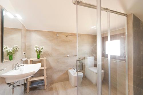 a bathroom with a sink and a toilet and a shower at Villa Anbegia in Siracusa