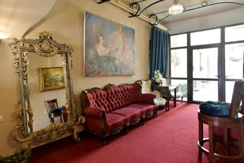 a living room with a red couch and a mirror at Safrano Palace in Braşov