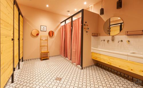 baño con bañera grande y lavamanos en The Yard Hostel en Catania