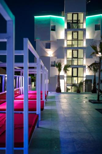 a row of red benches in front of a building at night at Boutique Residence Cosmopolis in Bibinje