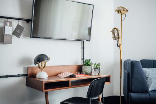 a desk with a chair and a tv on a wall at Vienna House by Wyndham Amber Baltic Miedzyzdroje in Międzyzdroje