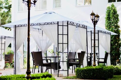 a table and chairs under an umbrella on a patio at Vele Rosse Hotel, business & leisure in Odesa