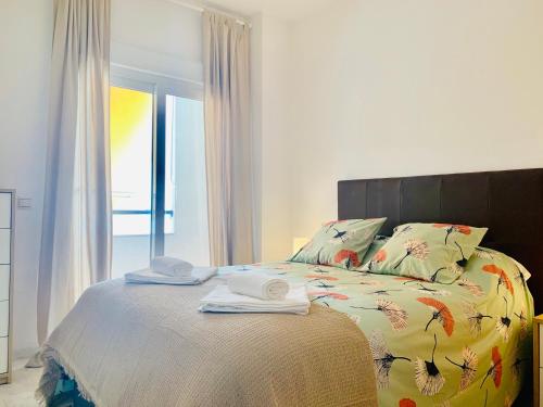 En eller flere senge i et værelse på Homely Málaga Parras con terraza interior y parking privado bajo suplemento