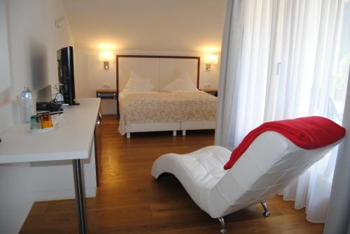 a bedroom with a bed and a desk and a chair at Hotel & Restaurant Dankl in Lofer