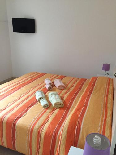 a bedroom with a bed with three stuffed animals on it at Ginepro family in Valledoria