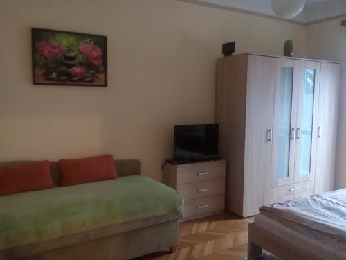 a living room with a couch and a dresser at Fészek Apartman in Békéscsaba