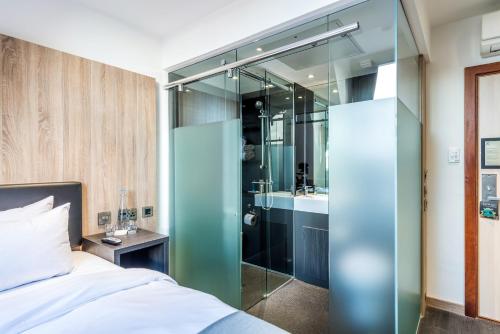a hotel room with a bed and a shower at The Z Hotel Glasgow in Glasgow
