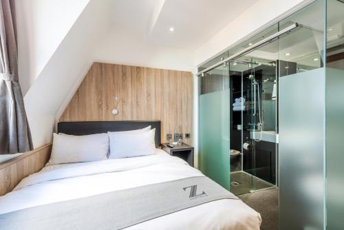 a bedroom with a bed and a glass shower at The Z Hotel Glasgow in Glasgow