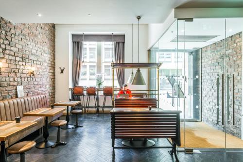 a restaurant with tables and chairs and a brick wall at The Z Hotel Glasgow in Glasgow