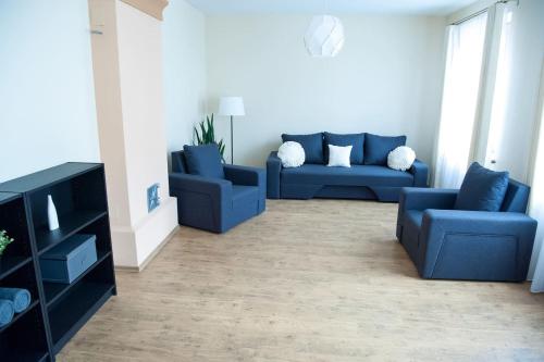 a living room with two blue couches and a table at Center Orange house in Cēsis