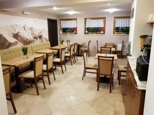 een restaurant met houten tafels en stoelen in een kamer bij Pensjonat Arnika in Zakopane
