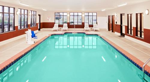a pool in a hotel room with chairs at Baymont by Wyndham St. Joseph/Stevensville in Stevensville