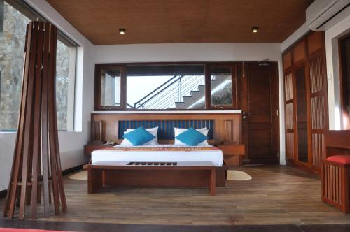 a bedroom with a bed with blue pillows and a window at Laya Safari Resorts & Spa in Yala