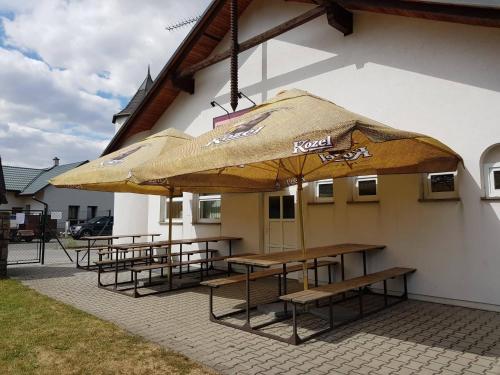 a group of tables and umbrellas outside of a building at Penzion Cerhenice in Cerhenice