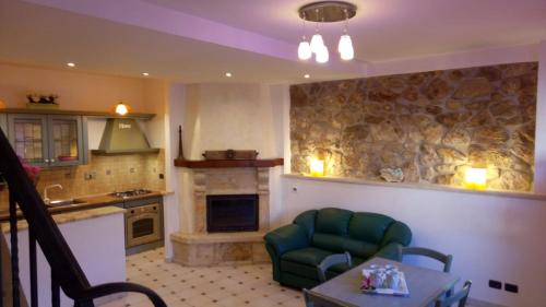 a kitchen with a couch and a chair and a table at Casetta degli Etruschi ALLOGGIO TURISTICO in Allumiere