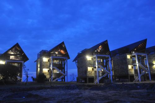 a group of buildings at night with lights at Laya Safari Resorts & Spa in Yala