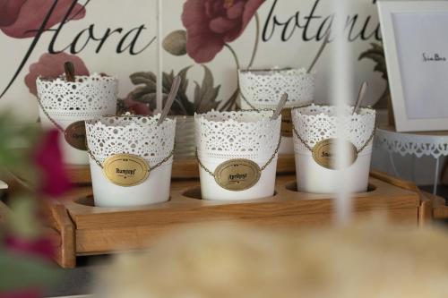 a group of cups on a wooden tray with flowers at Pension Magdalena in Altossiach