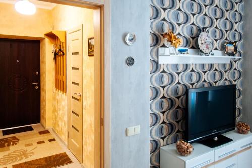 a living room with a television and a hallway with a door at Pushkinskaya street in Kharkiv