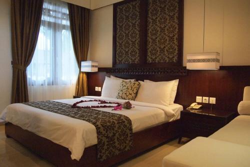 a bedroom with a large bed in a hotel room at Yulia Village Inn Ubud in Ubud