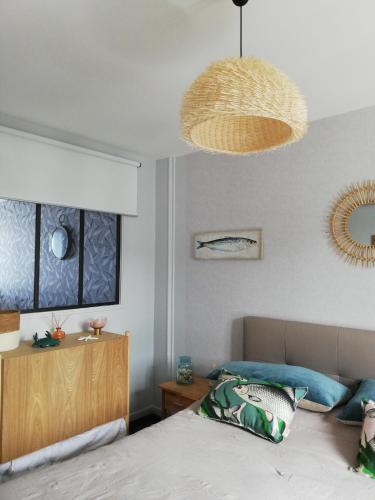 une chambre avec un lit et un lustre dans l'établissement L'ENTRE 2 COTES, au Tréport