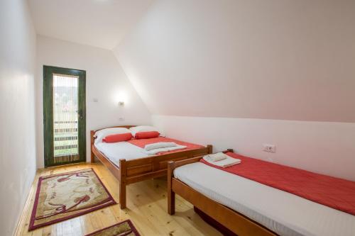 two beds in a small room with a window at Guest house Sky Blue in Žabljak