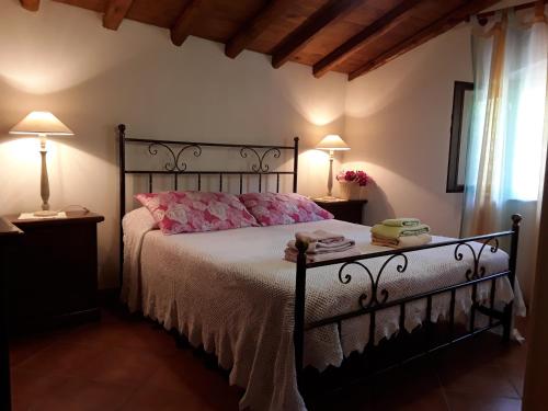 a bedroom with a black bed with pink pillows at A Casa da Paola in Taormina