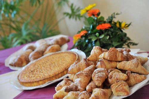 a table topped with plates of bread and pastries at Tulip Inn Turin South in Moncalieri