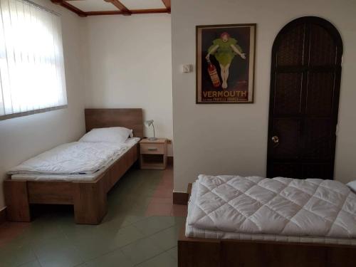a bedroom with two beds and a picture on the wall at Penzion Cerhenice in Cerhenice