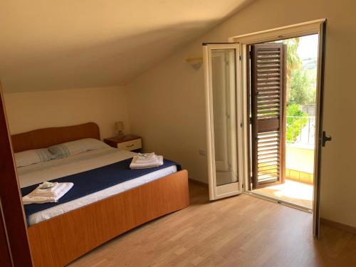 a bedroom with a bed and a sliding glass door at B&B Collemare in Drapia