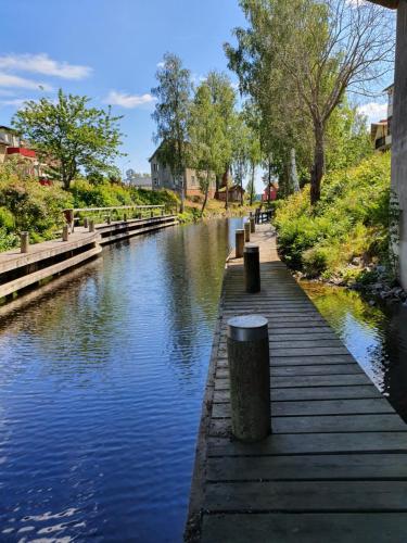 a river with a wooden walkway next to a canal at Valhalla bengtfors Private house in Bengtsfors