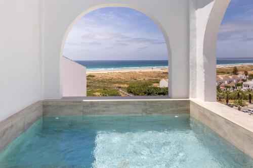 a swimming pool with an ocean view from a house at Zahara Beach & Spa by QHotels - Adults Recommended in Zahara de los Atunes