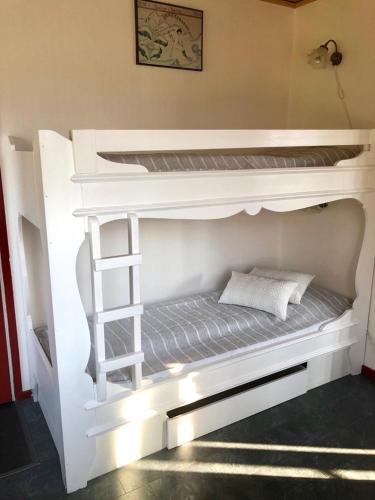 a white bunk bed with a ladder in a room at Prinsgården B&B rum stugor in Mora