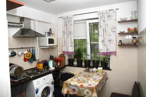 eine Küche mit einem Tisch und einem Fenster in der Unterkunft Vash Dom in Murmansk