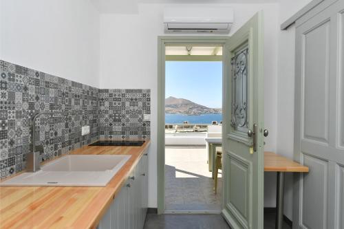 a kitchen with a sink and a view of the ocean at Lorenzo Studios and Suites Paros in Naousa