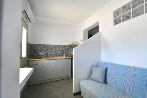 a white kitchen with a blue couch in a room at Lorenzo Studios and Suites Paros in Naousa