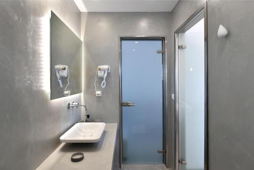 a bathroom with a sink and a mirror at Lorenzo Studios and Suites Paros in Naousa