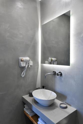 a bathroom with a bowl sink and a mirror at Lorenzo Studios and Suites Paros in Naousa