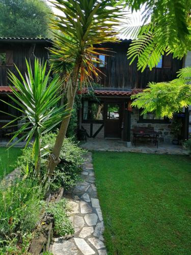 un jardín con una palmera frente a una casa en Iturbe1 en Busturia