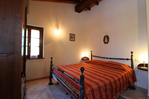 a bedroom with a bed with a orange comforter at Il Viaggiolo in Foiano della Chiana