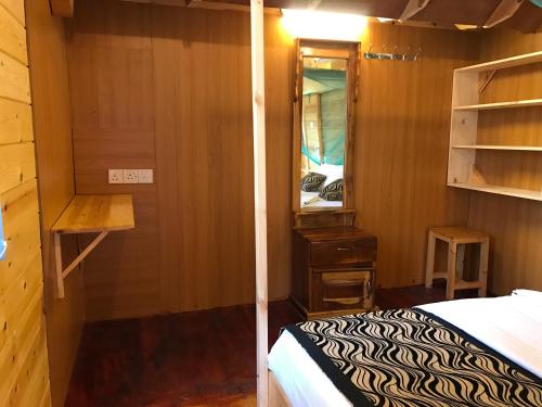 a small room with a bed and a mirror at Sasvi Cabana in Trincomalee