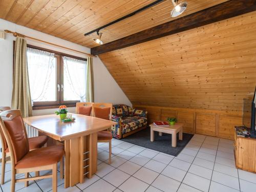 トートナウベルクにあるCosy apartment in Todtnauberg in the Black Forest with private terraceの木製の天井のリビングルーム(テーブル、椅子付)