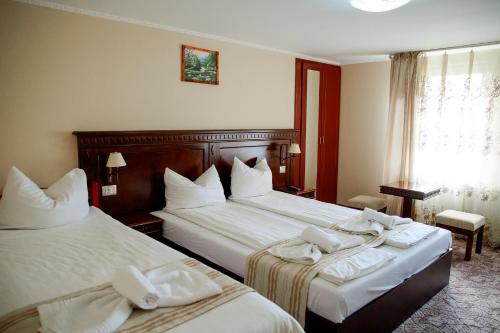 a hotel room with two beds with towels on them at Giandra Resort in Turda