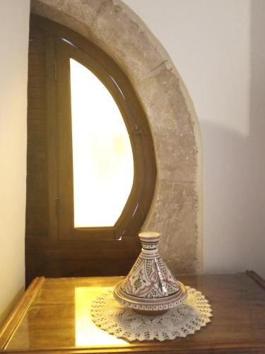 a vase sitting on a table in front of a mirror at Riad Etoile De Mogador in Essaouira