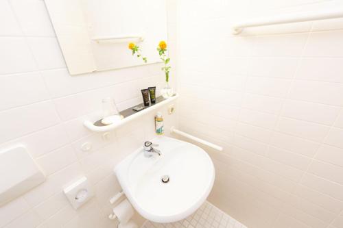 a white bathroom with a toilet and a sink at Wilhelm-Kempf-Haus in Wiesbaden