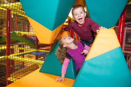 two young children playing on an indoor playground at ibis Styles Saint Julien en Genevois Vitam in Neydens