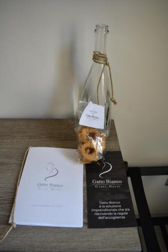 a glass bottle with a cookie in it on a table at Gatto Bianco Duchessa in Bari