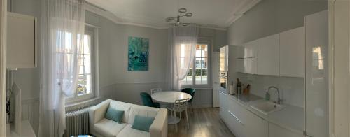 ein weißes Wohnzimmer mit einem Sofa und einem Waschbecken in der Unterkunft Relais Vacances à la Mer in Berck-sur-Mer