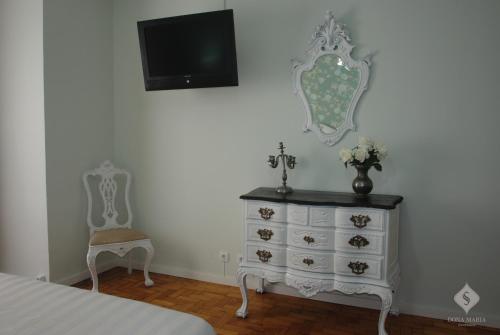 a bedroom with a dresser and a tv and a chair at Dona Maria in Portalegre