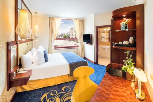 a hotel room with a bed and a balcony at Occidental Praha Wilson in Prague