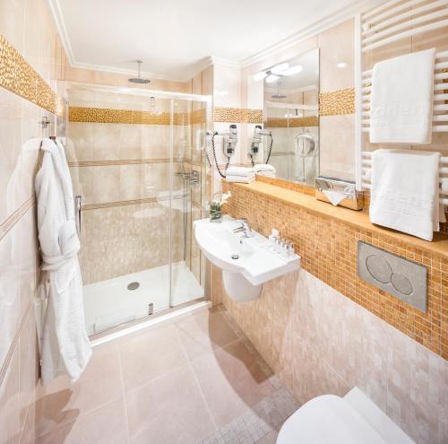 a bathroom with a shower toilet and a sink at Occidental Praha Wilson in Prague